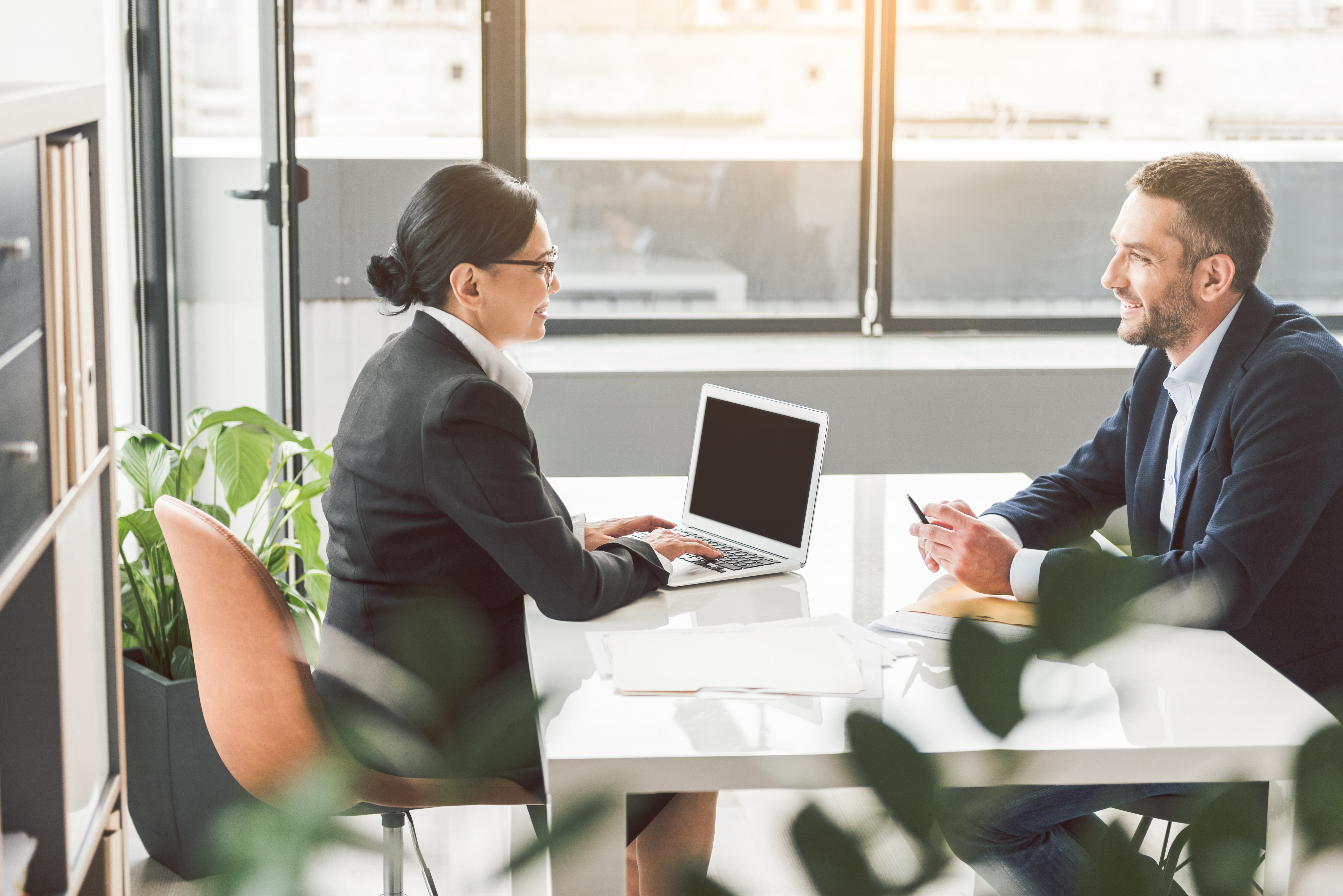 HR professional meeting with a manager at a desk to discuss performance documentation and review materials